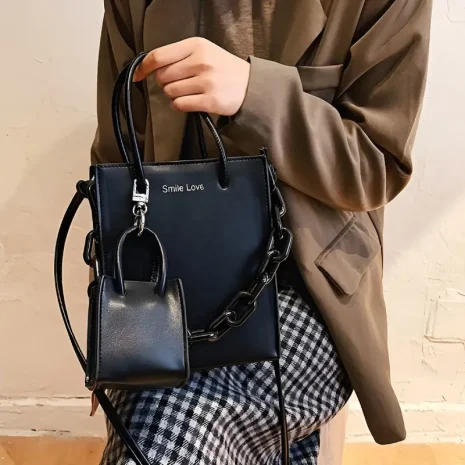 black tote bag with mini bag charm model